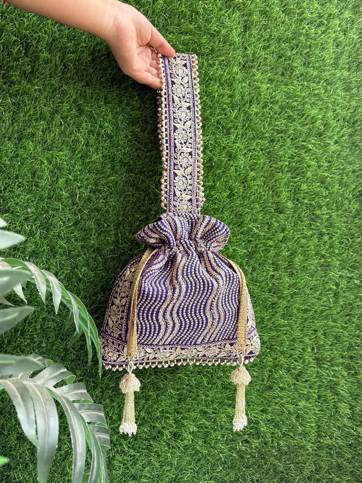 Decorative purple handbag with intricate patterns, unique tassels & handle