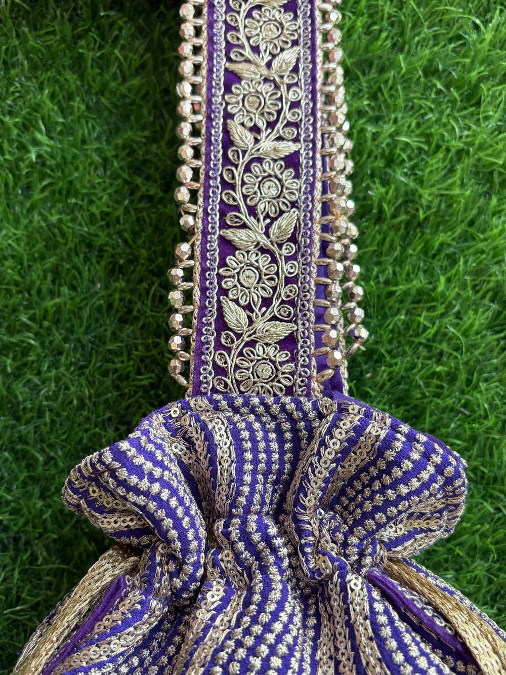 Decorative purple handbag with intricate patterns, unique tassels & handle