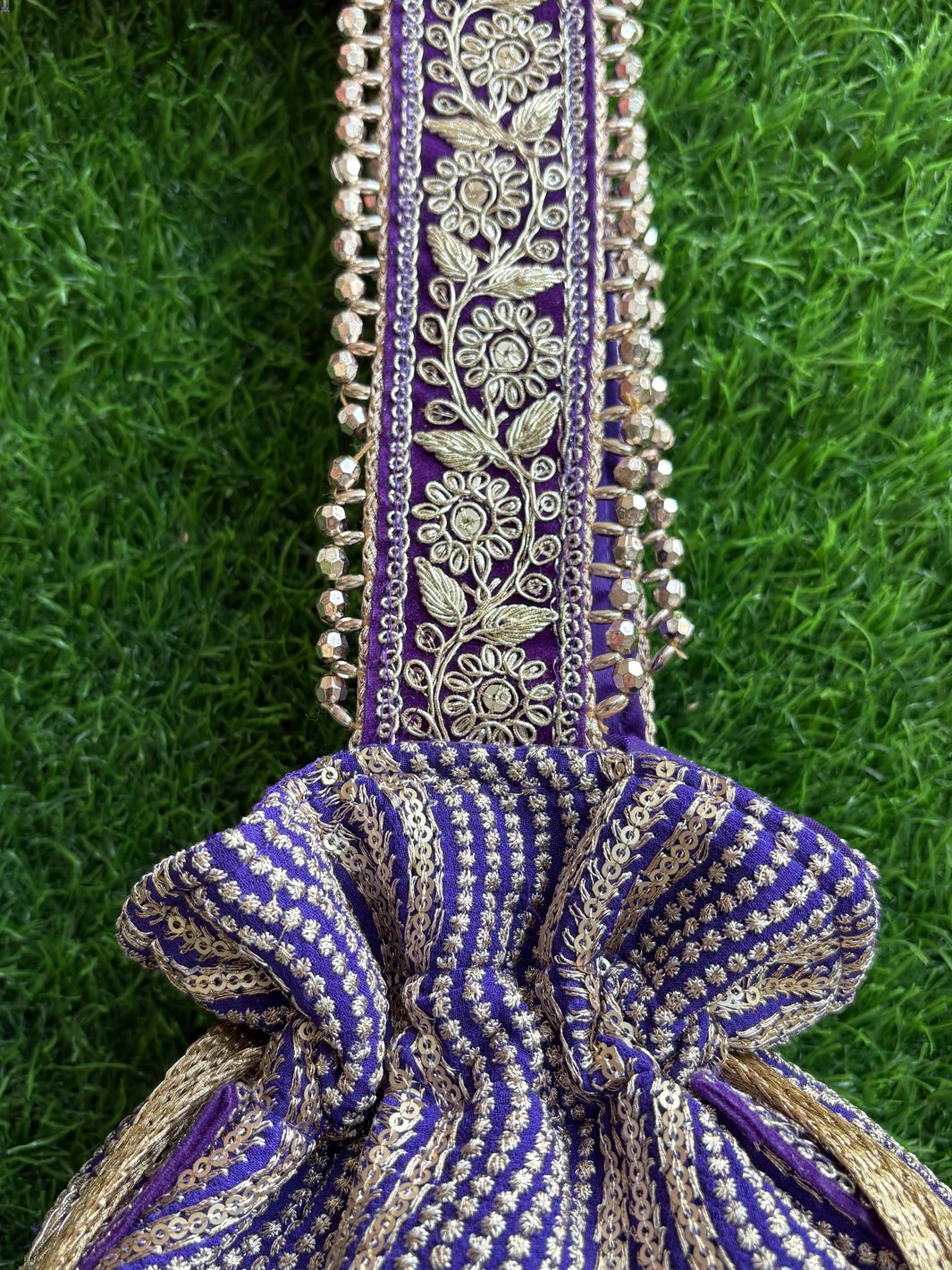 Decorative purple handbag with intricate patterns, unique tassels & handle