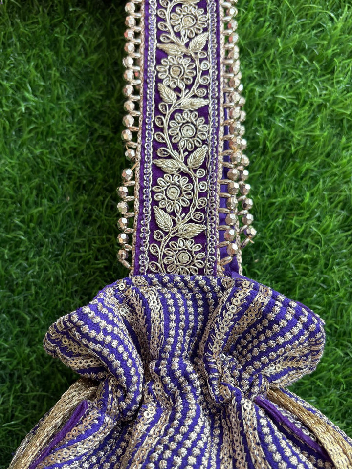 Decorative purple handbag with intricate patterns, unique tassels & handle