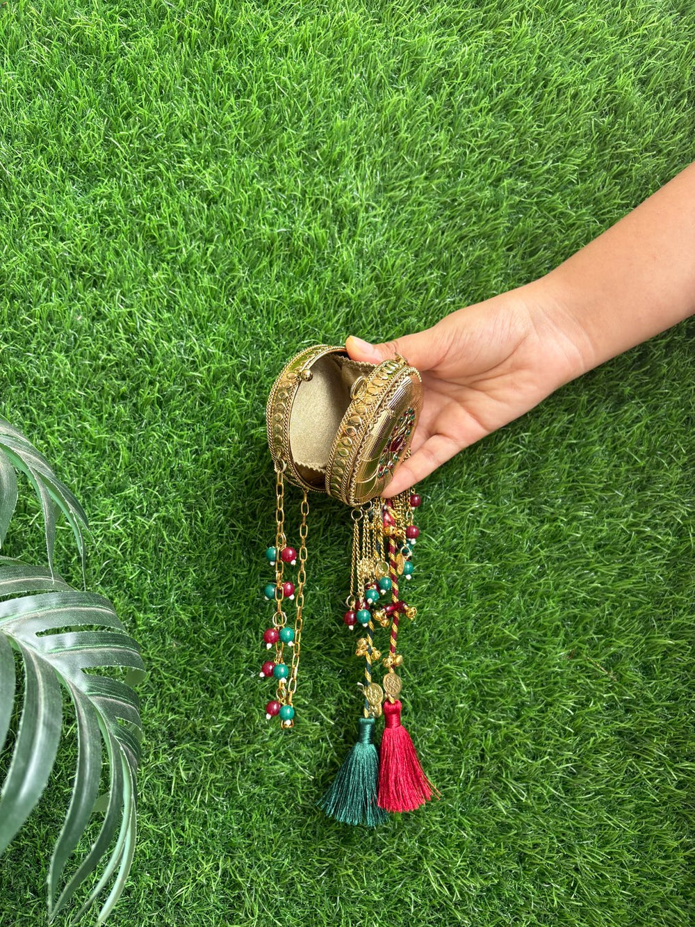 Gold wedding clutch with maroon and green tassel detailing
