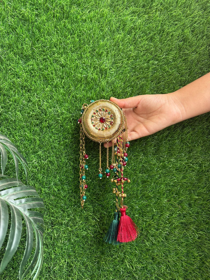 Mini gold metal clutch bag with contrasting green tassels